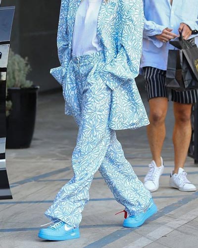 flat shoe trends summer 2022 - blue nike sneakers styled with flower printed oversized suit